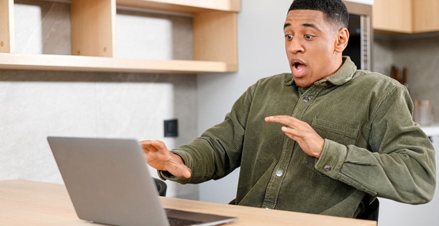 man surprised by something on his laptop screen