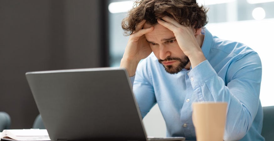 Man at laptop worrying about technology hassles