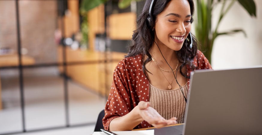 Woman in a video conferencing call on laptop with headphones