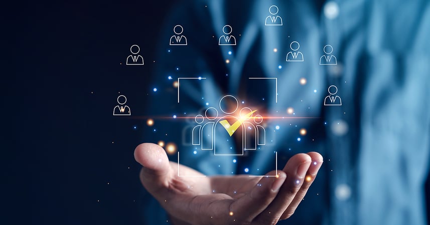 a man's hand holding an image of icons representing people at a large business