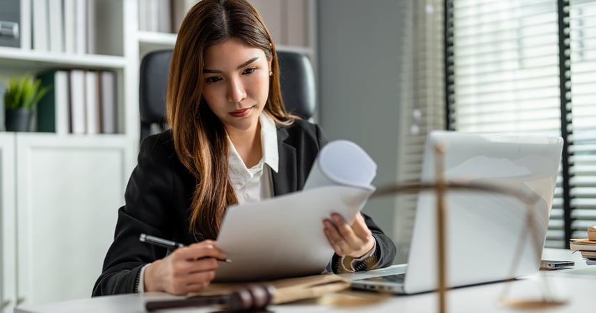 Female lawyer sitting at desk reviewing paperwork