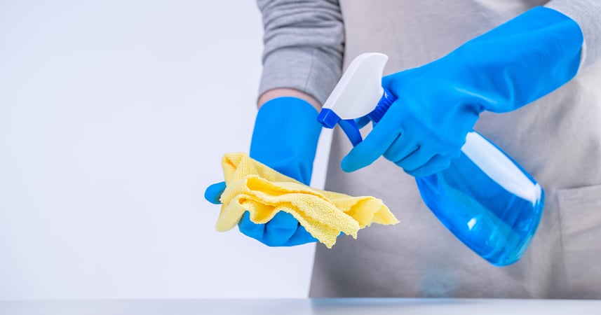 spraying cleaning solution on cloth