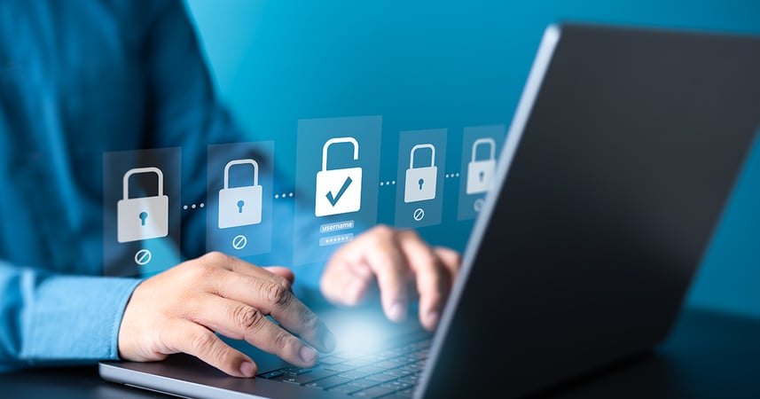 man typing at a laptop computer with a graphic above showing three locked padlocks and one unlocked padlock with a checkmark over it