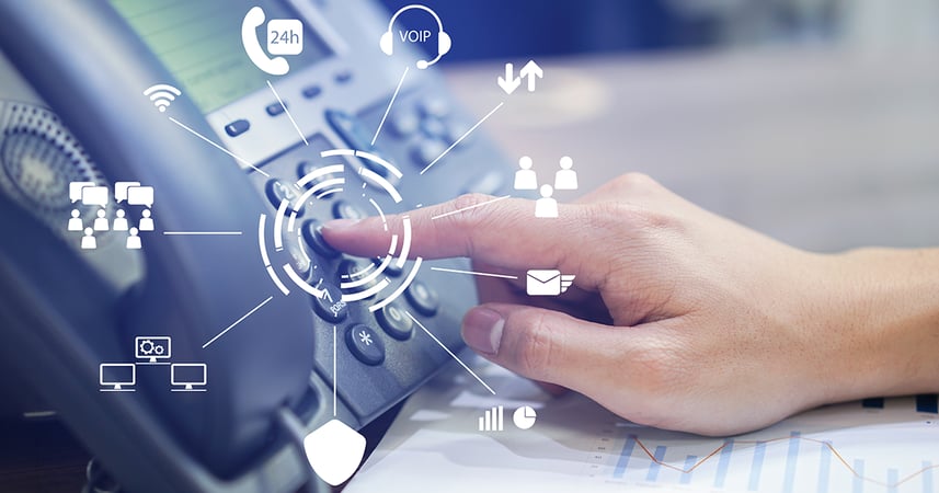 hand of an employee pushing buttons to dial an office phone on a desk