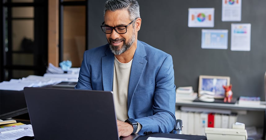 Man at desk in busy workplace