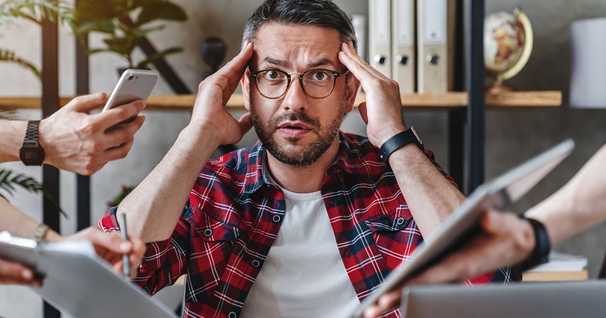 Overwhelmed man with fingertips on his forehead