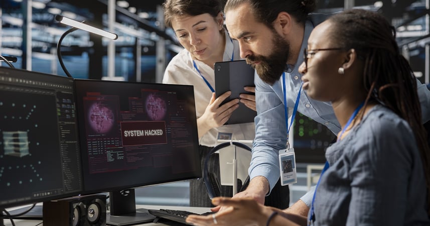 three co-workers viewing a computer screen that says, 