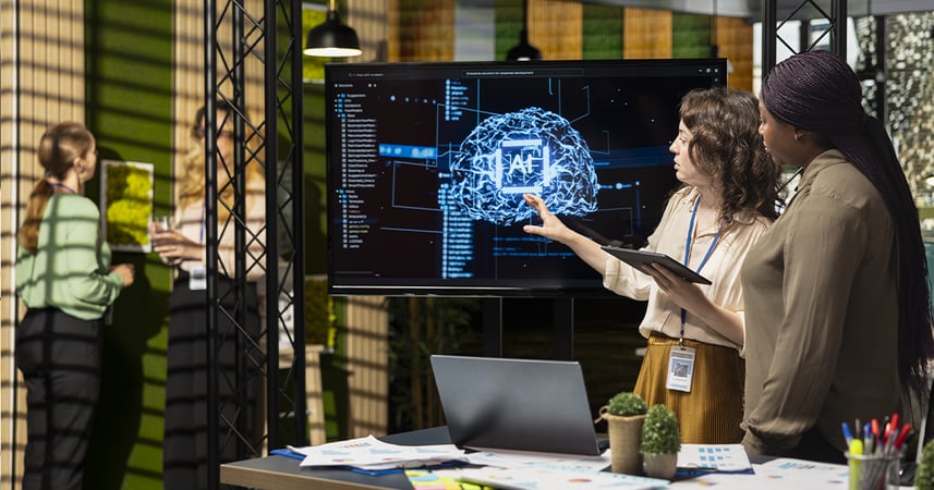 Woman in office pointing at a screen showing a neural AI network