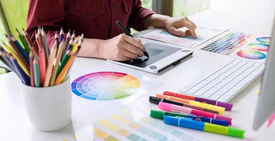 Graphic Designer consulting a color wheel in a corporate office setting