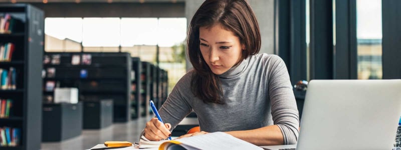 woman_studying_in_library_with_laptop