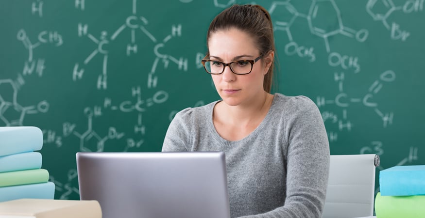 woman in science class looking at laptop