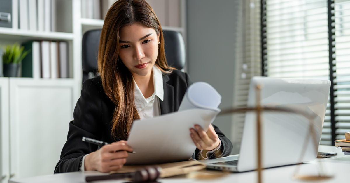 Female lawyer sitting at desk reviewing paperwork