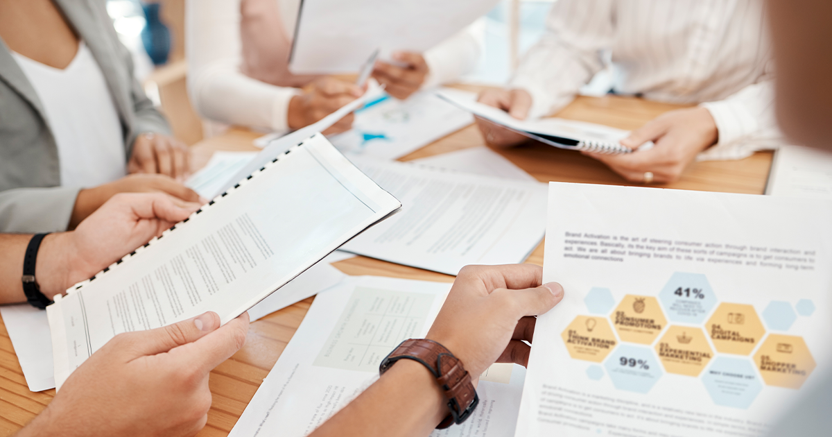 Attendees looking at printed presentations during a meeting