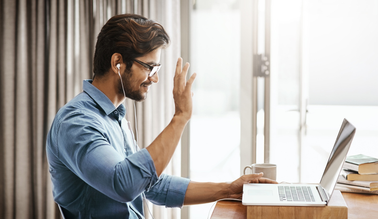 Person waving in video conference.