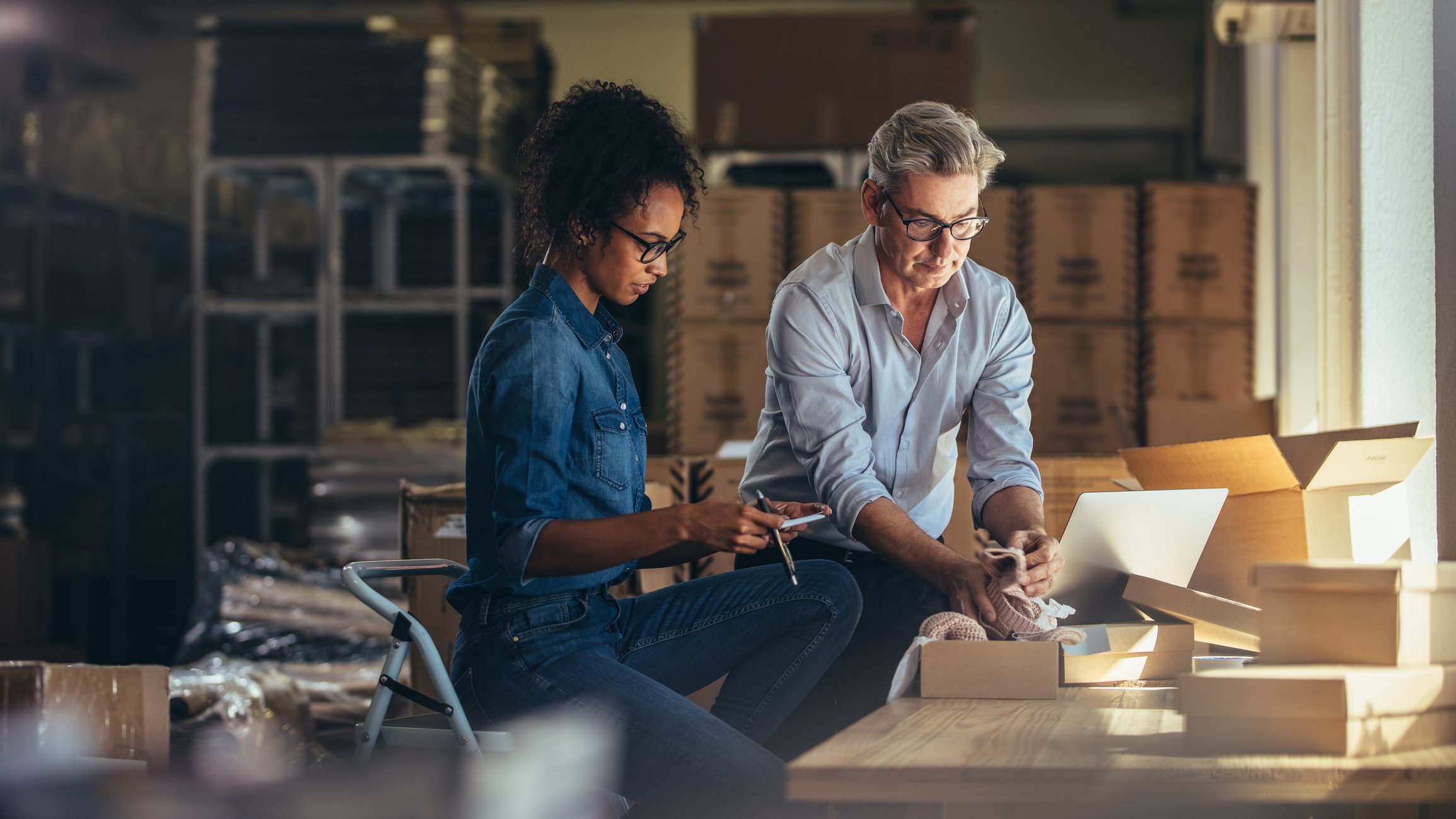 man and woman in office around laptop
