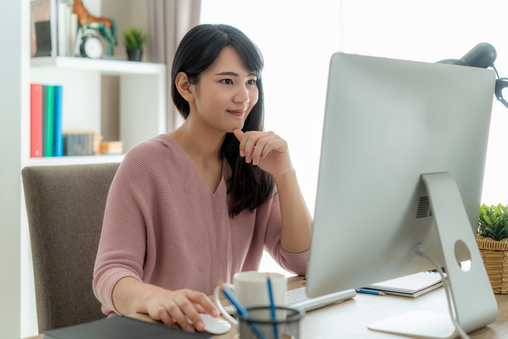 woman looking at computer in home office
