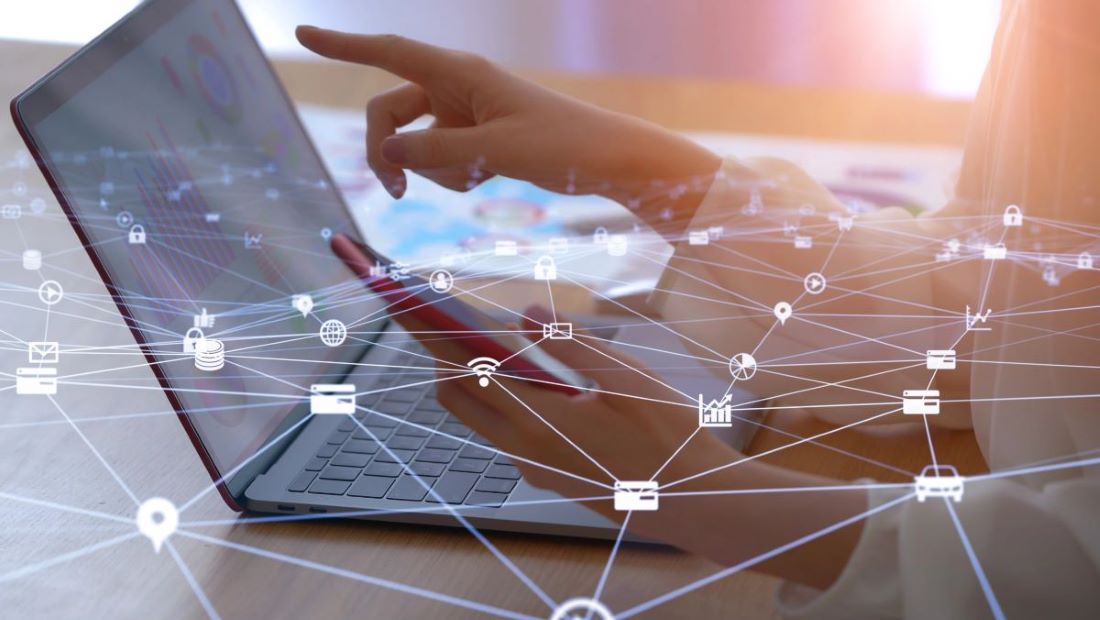 person's hands with laptop and network of internet things