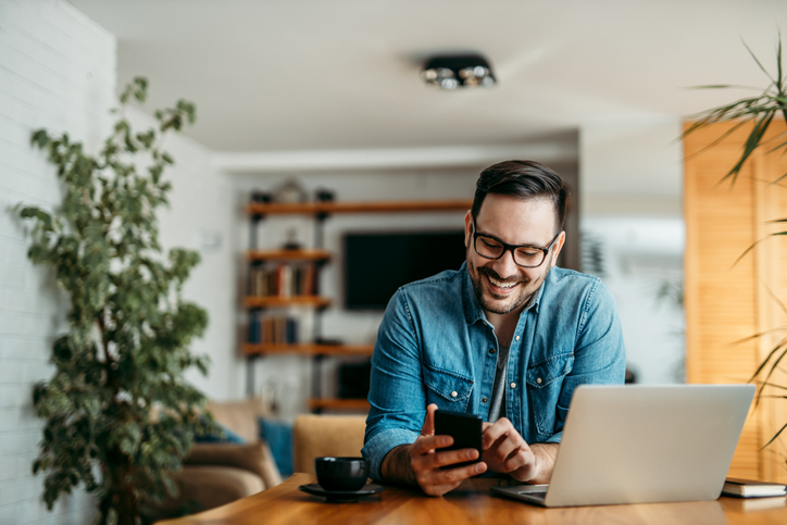 man looking at mobile phone working from home
