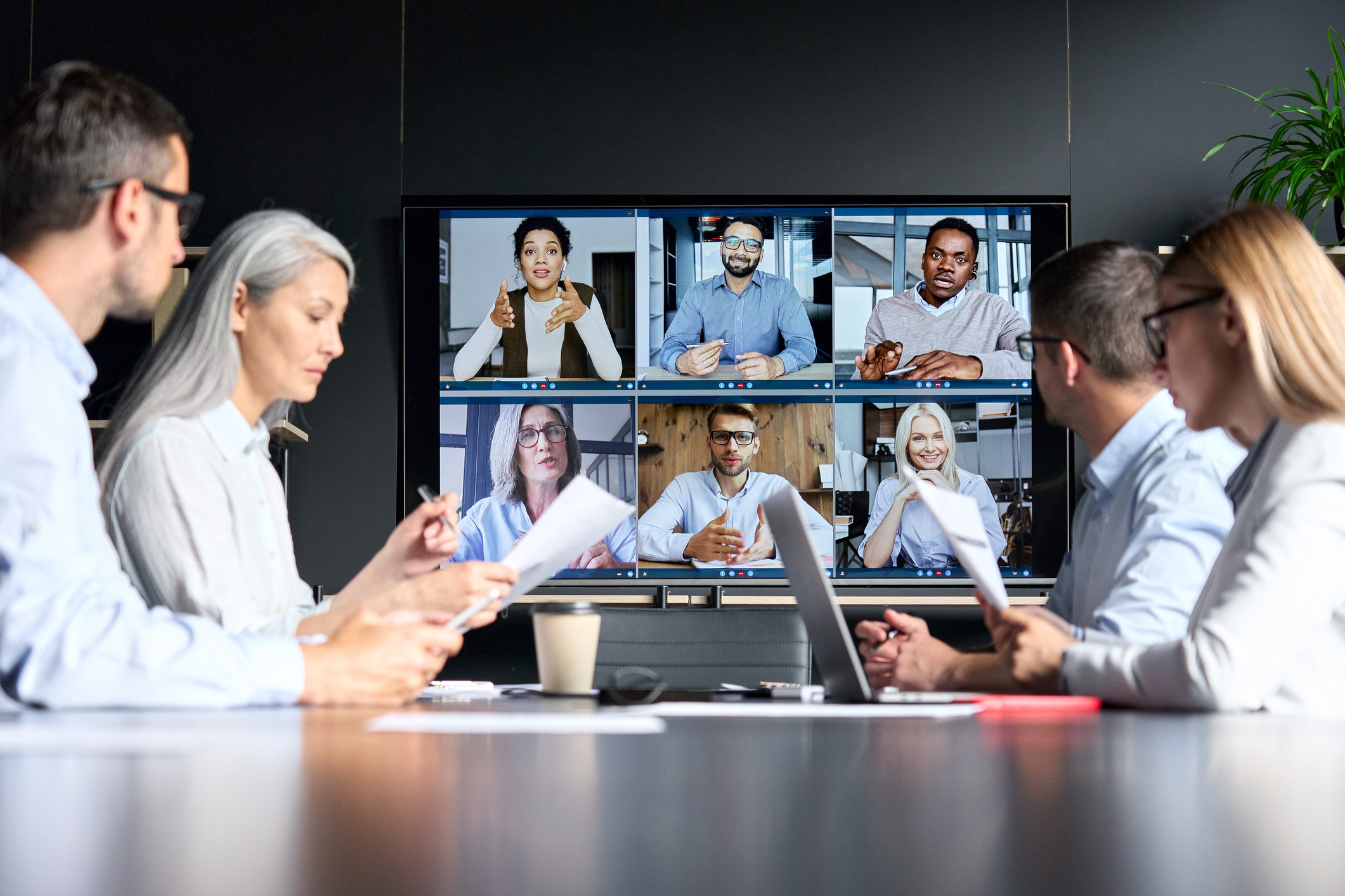 an online meeting with people sitting in a conference room