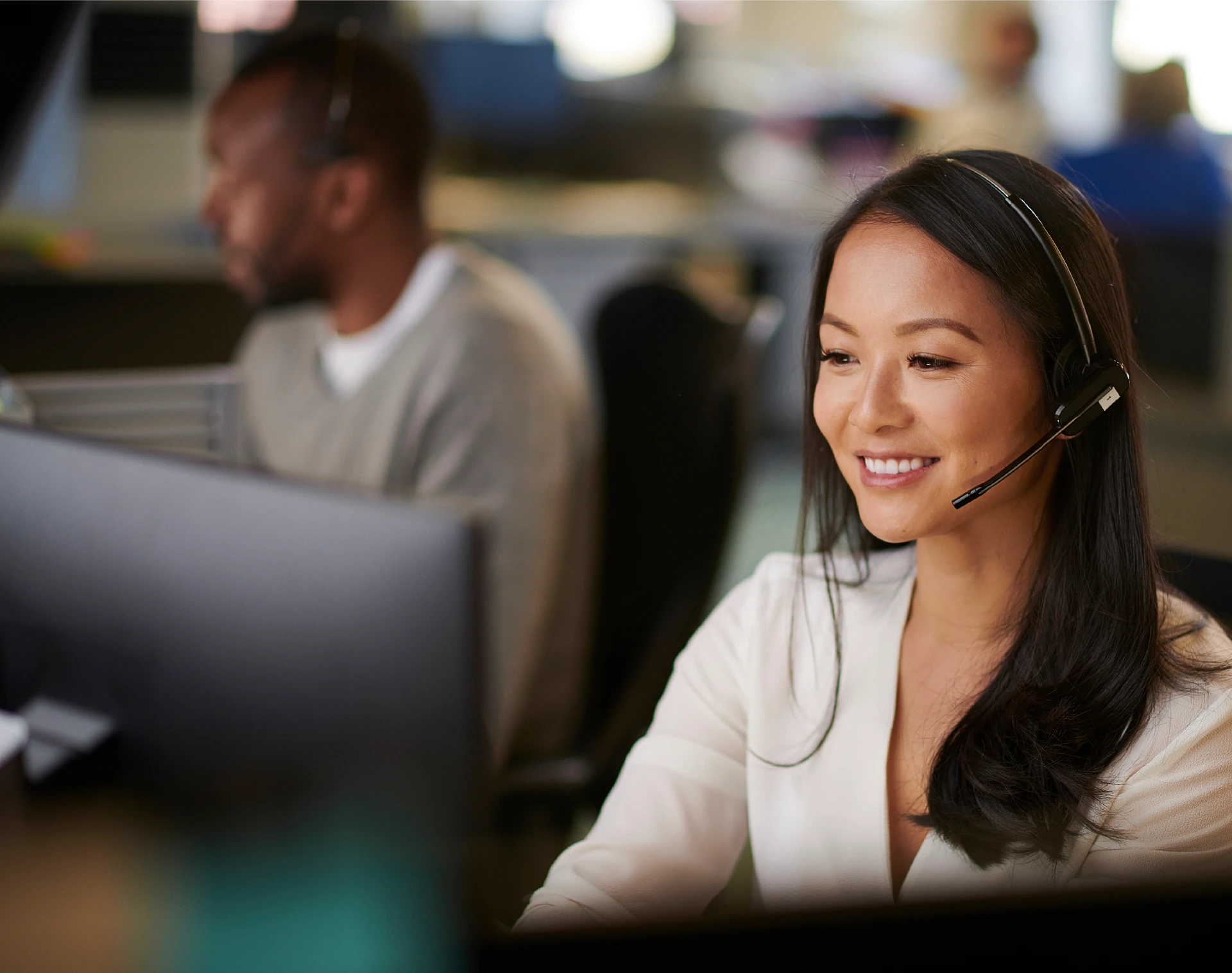 person on headset sitting at desktop computer